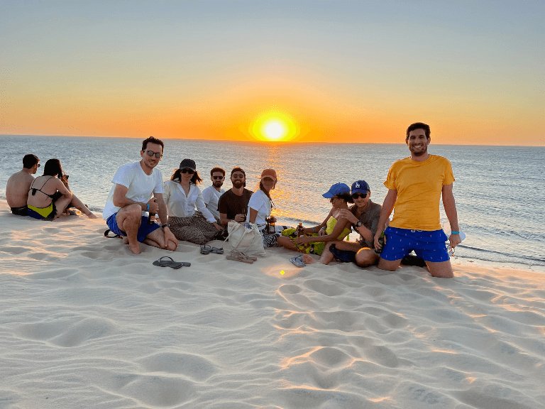 Alessandro con i suoi amici su un tramonto in spiaggia in Brasile.